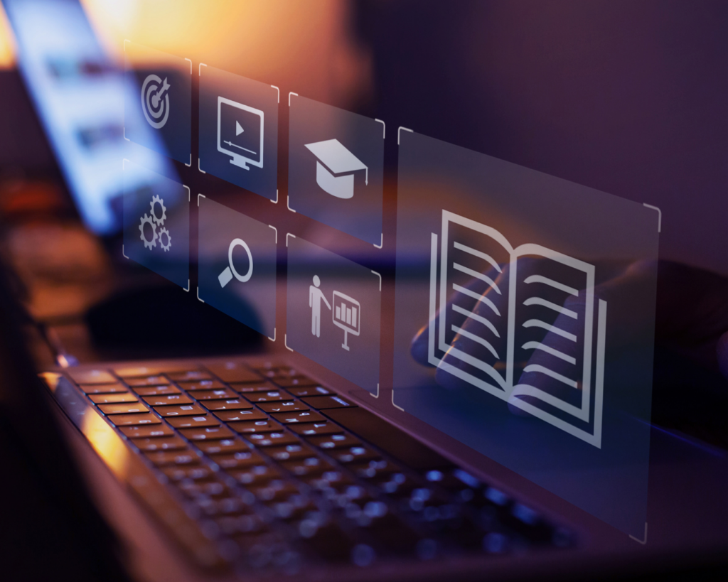 Hologram icons hover over a laptop, representing images of an open book, graduation cap, a teacher, a search button, and a video playback button.